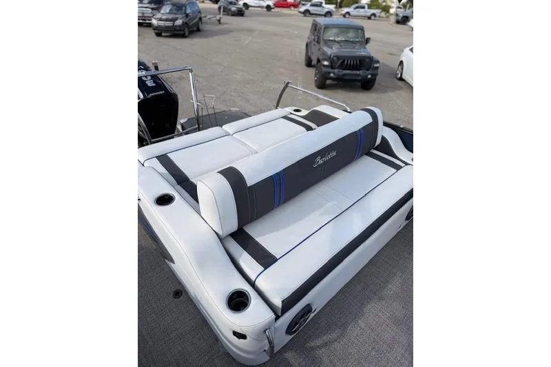 Slide: The Image of 2025 Barletta Corsa 23UC boat with white and black seating in a parking lot. - 23