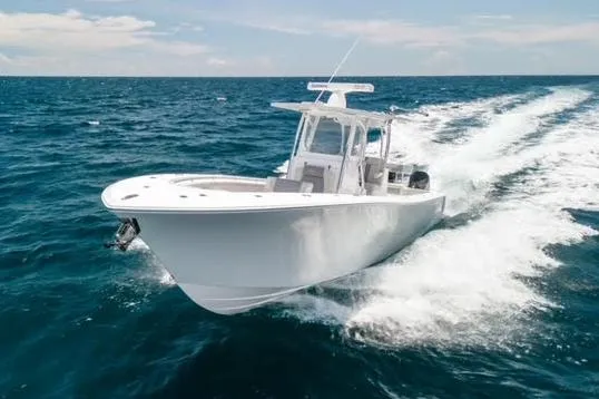 Slide: The Image of 2026 Front Runner 33 Center Console boat on trailer, parked outside a garage. - 2