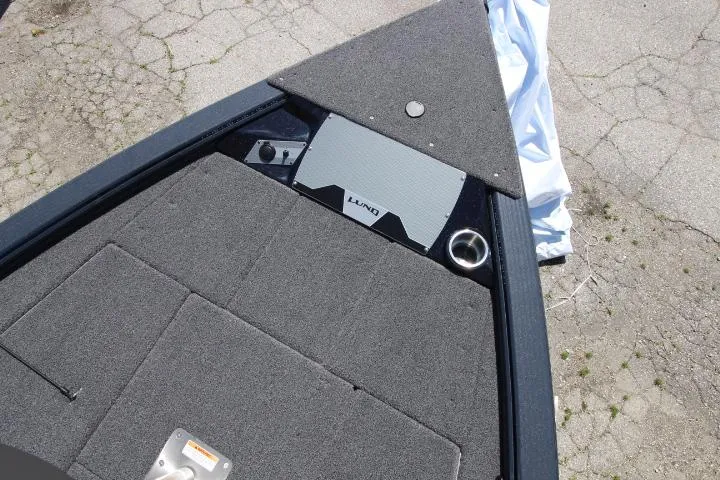 Slide: The Image of 2025 Lund 1875 Pro-V Bass XS boat deck with carpeted surface and storage compartments. - 4