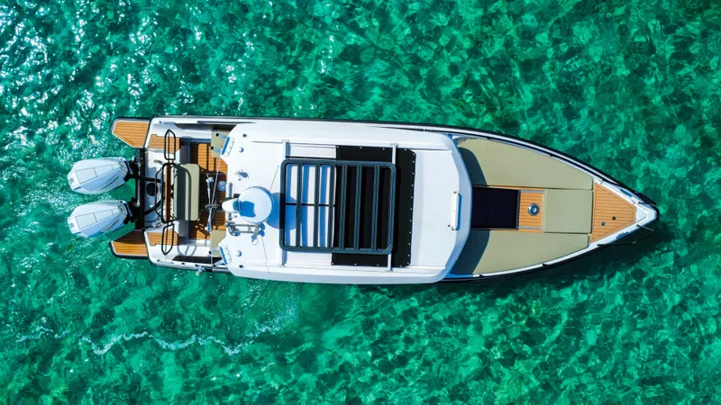 Slide: The Image of 2024 XO Boats EXPLR 10S Plus on clear turquoise water, aerial view. - 1