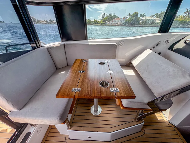 Slide: The Image of Interior of 2024 XO Boats EXPLR 10S Plus with wooden table and cushioned seating. - 17
