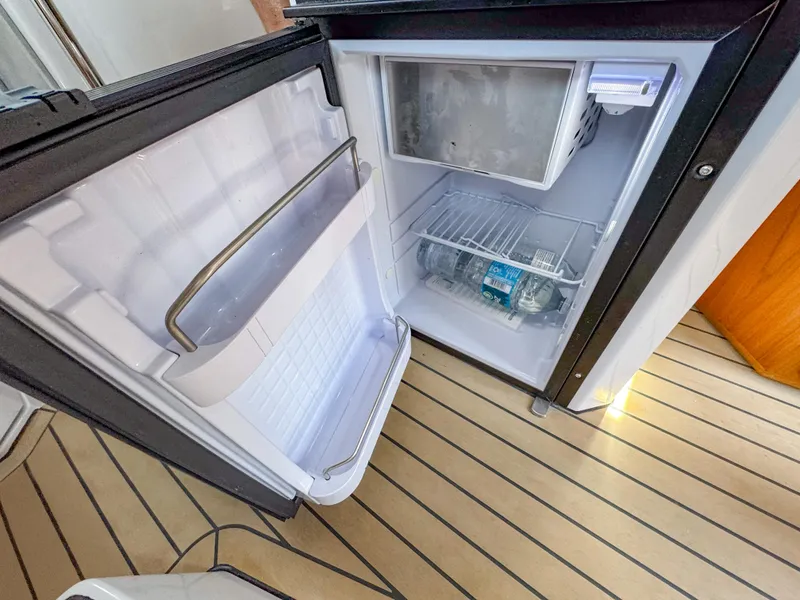 Slide: The Image of Open fridge on XO Boats EXPLR 10S Plus, 2024 model, with wooden flooring. - 30
