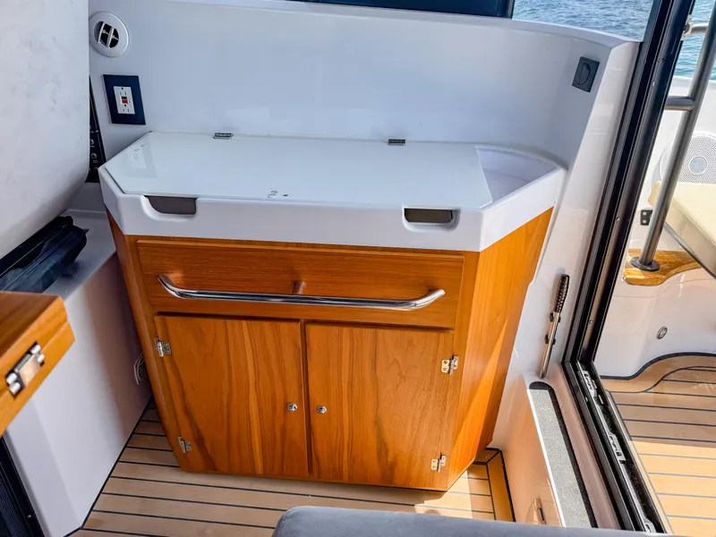 Slide: The Image of 2024 XO Boats EXPLR 10S Plus interior with wooden cabinetry and sleek design. - 31