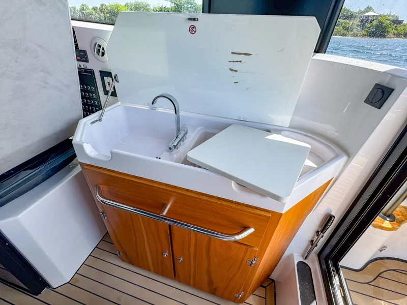 Slide: The Image of 2024 XO Boats EXPLR 10S Plus interior sink with wooden cabinetry and modern design. - 32
