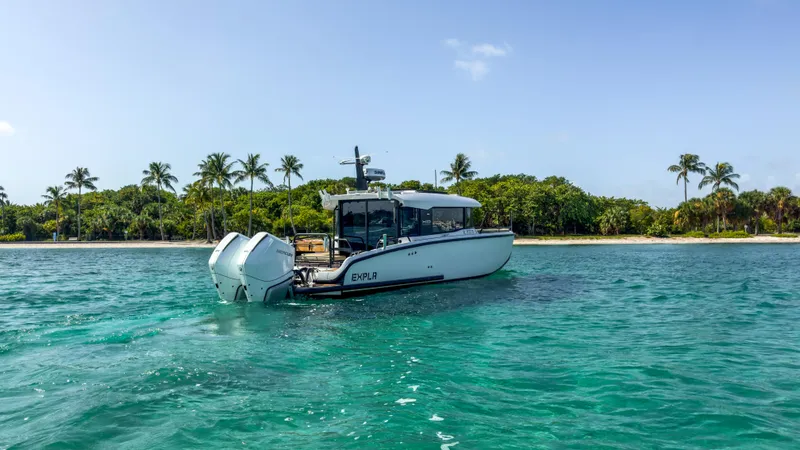 Slide: The Image of 2024 XO Boats EXPLR 10S Plus cruising near a tropical shoreline with palm trees. - 35