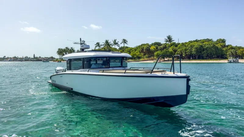 Slide: The Image of 2024 XO Boats EXPLR 10S Plus cruising near a tropical shoreline. - 38