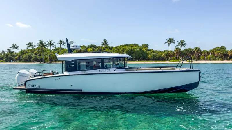 Slide: The Image of 2024 XO Boats EXPLR 10S Plus cruising near a tropical shoreline with palm trees. - 39
