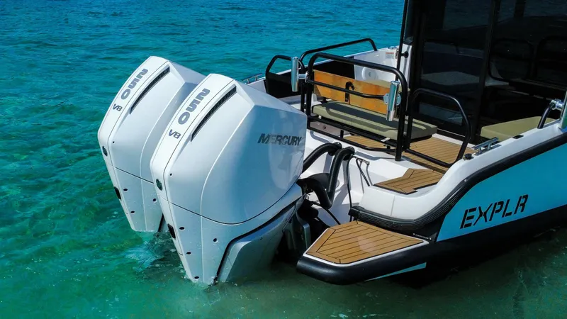 Slide: The Image of 2024 XO Boats EXPLR 10S Plus with dual Mercury V8 engines in clear blue water. - 5