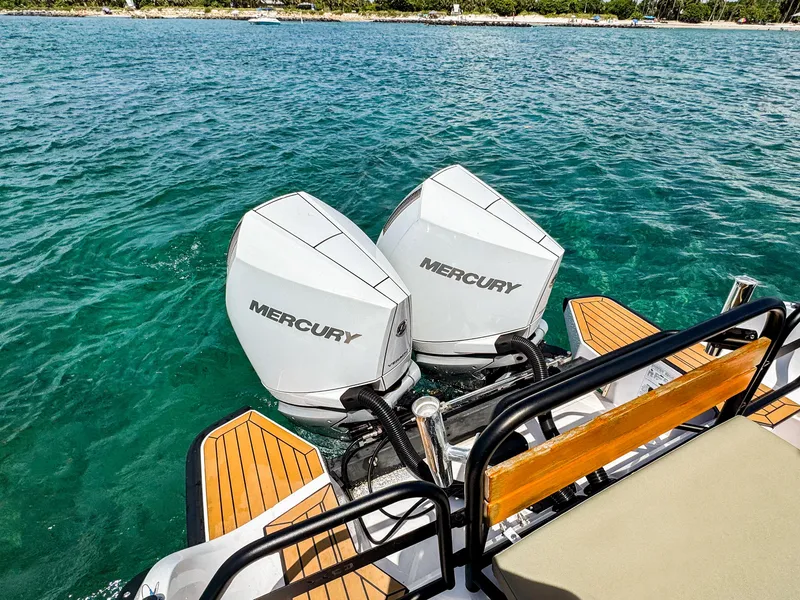 Slide: The Image of 2024 XO Boats EXPLR 10S Plus with dual Mercury outboard engines on clear water. - 7