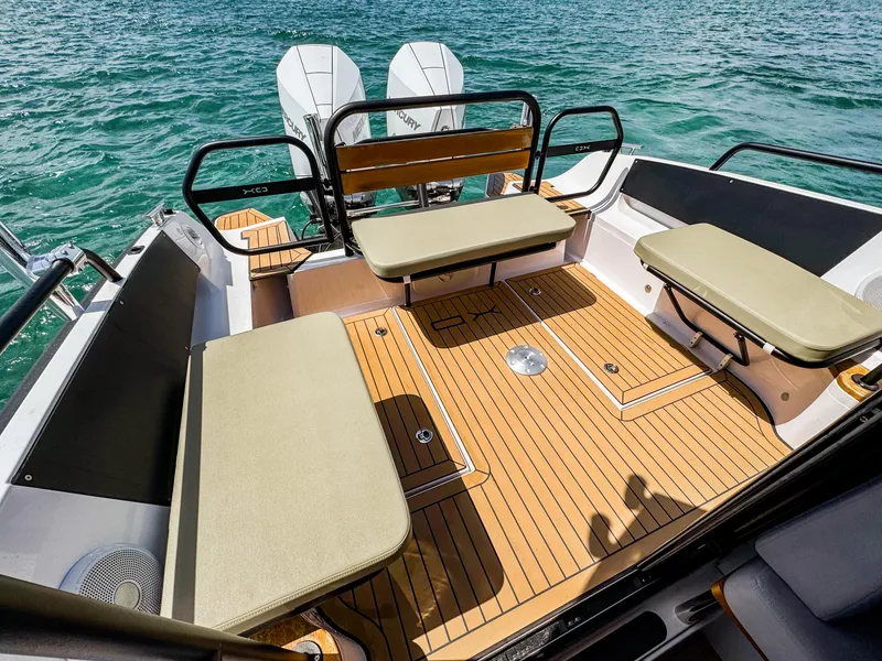 Slide: The Image of 2024 XO Boats EXPLR 10S Plus interior with cushioned seating and wooden deck. - 8