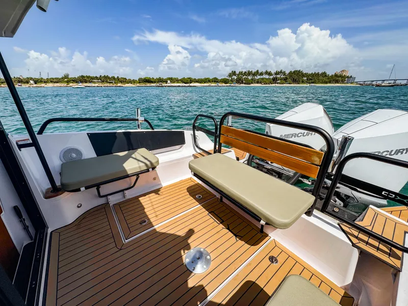 Slide: The Image of 2024 XO Boats EXPLR 10S Plus deck with seating, overlooking scenic ocean view. - 9