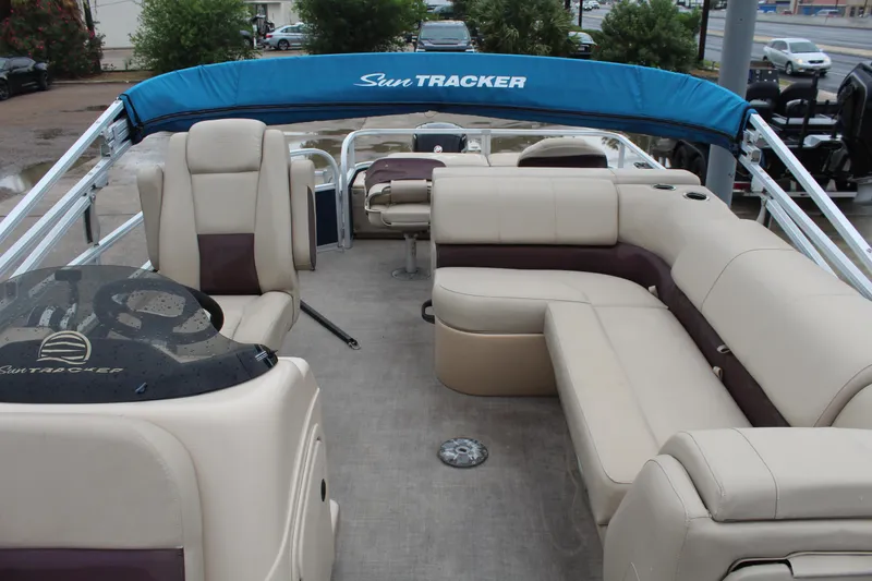 Slide: The Image of 2019 Sun Tracker Fishin' Barge 22 DLX with beige seating and blue canopy. - 10