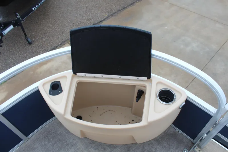 Slide: The Image of 2019 Sun Tracker Fishin' Barge 22 DLX storage compartment with cup holders and open lid. - 16