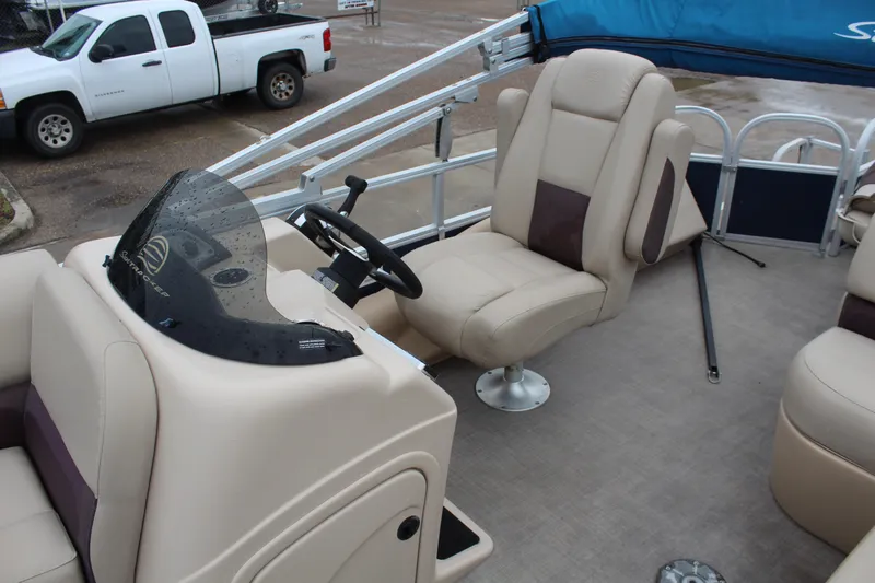 Slide: The Image of 2019 Sun Tracker Fishin' Barge 22 DLX interior with beige seating and steering console. - 17