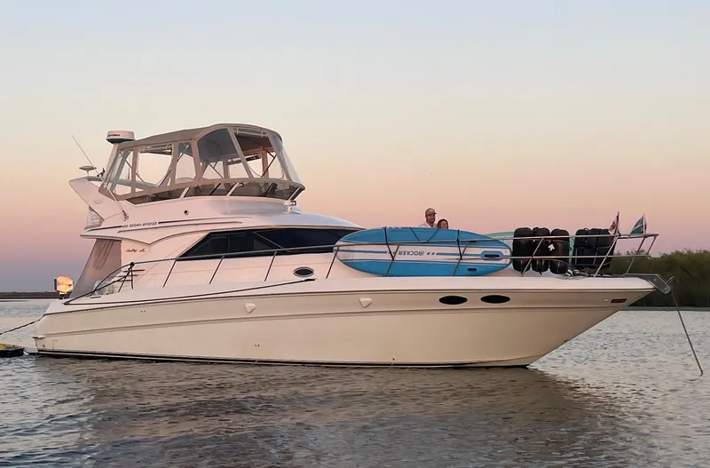 The Image of 1999 Sea Ray 400 Sedanbridge yacht on calm water at sunset. - 0