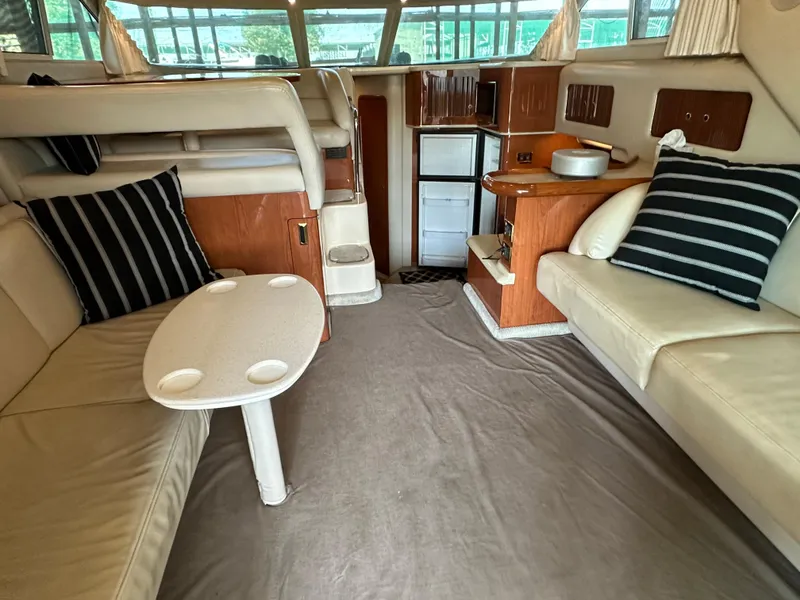 Slide: The Image of Interior of 1999 Sea Ray 400 Sedanbridge yacht with beige seating and striped cushions. - 12