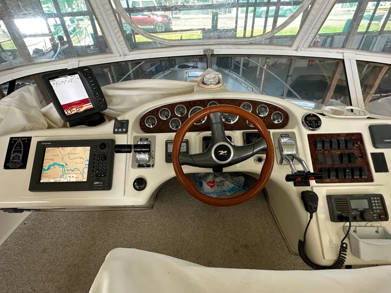 Slide: The Image of 1999 Sea Ray 400 Sedanbridge helm with navigation equipment and wooden steering wheel. - 25