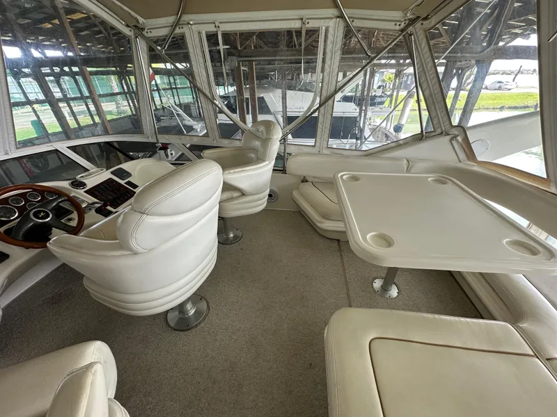 Slide: The Image of Interior of a 1999 Sea Ray 400 Sedanbridge yacht with white seating and a table. - 26