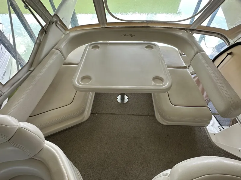Slide: The Image of 1999 Sea Ray 400 Sedanbridge interior with cushioned seating and table. - 27