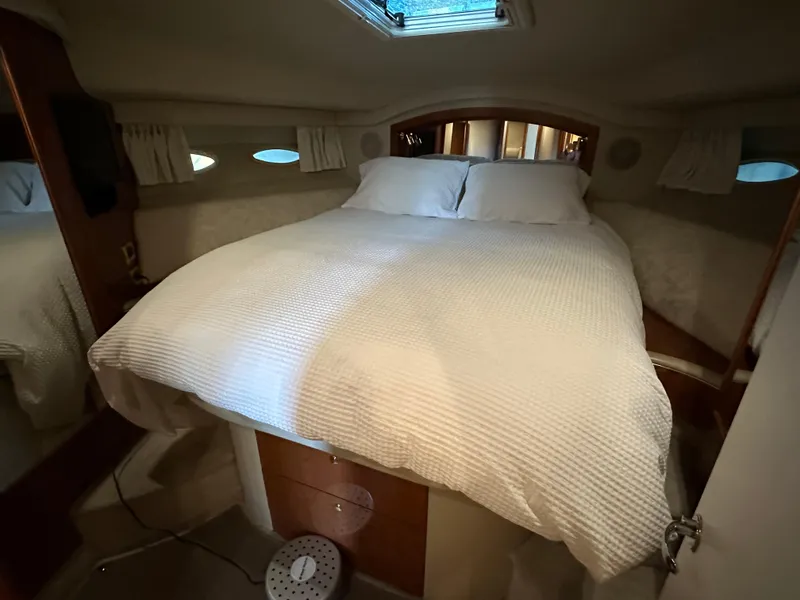 Slide: The Image of 1999 Sea Ray 400 Sedanbridge cabin with cozy bed and porthole windows. - 3