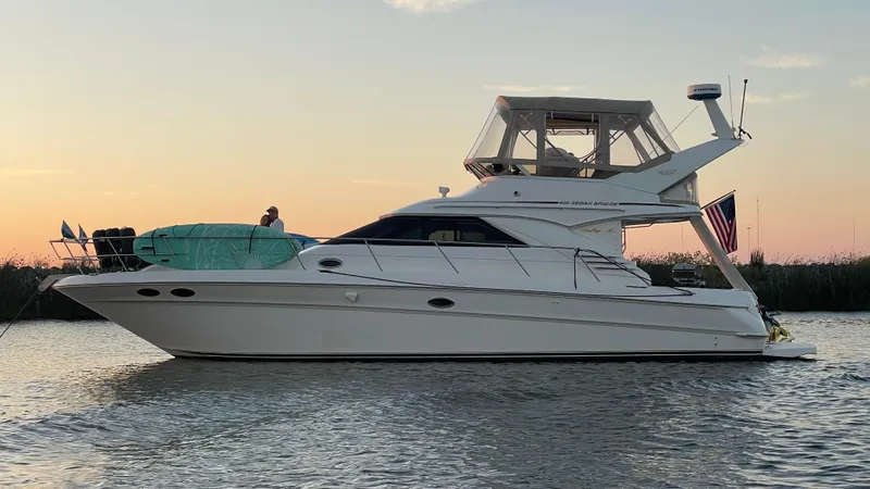 Slide: The Image of 1999 Sea Ray 400 Sedanbridge yacht on calm water at sunset. - 35