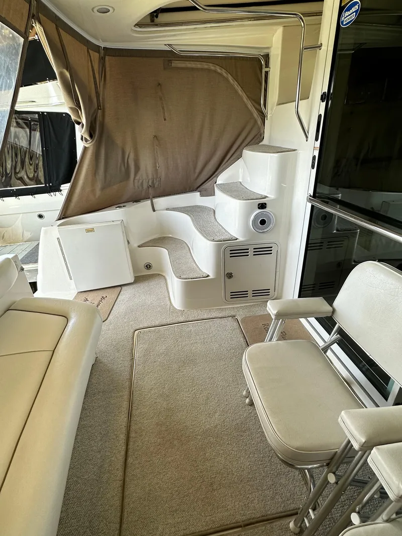 Slide: The Image of 1999 Sea Ray 400 Sedanbridge interior with seating, stairs, and carpeted flooring. - 5
