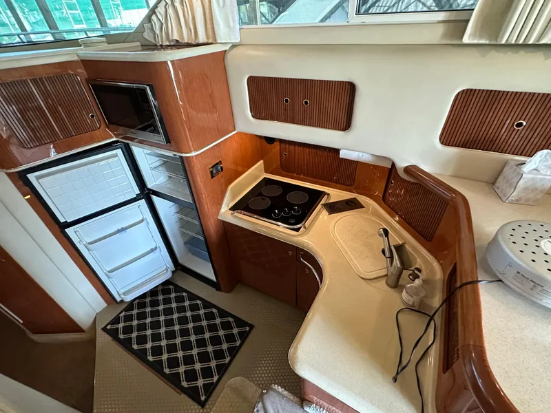 Slide: The Image of 1999 Sea Ray 400 Sedanbridge kitchen with stove, fridge, and microwave. - 6
