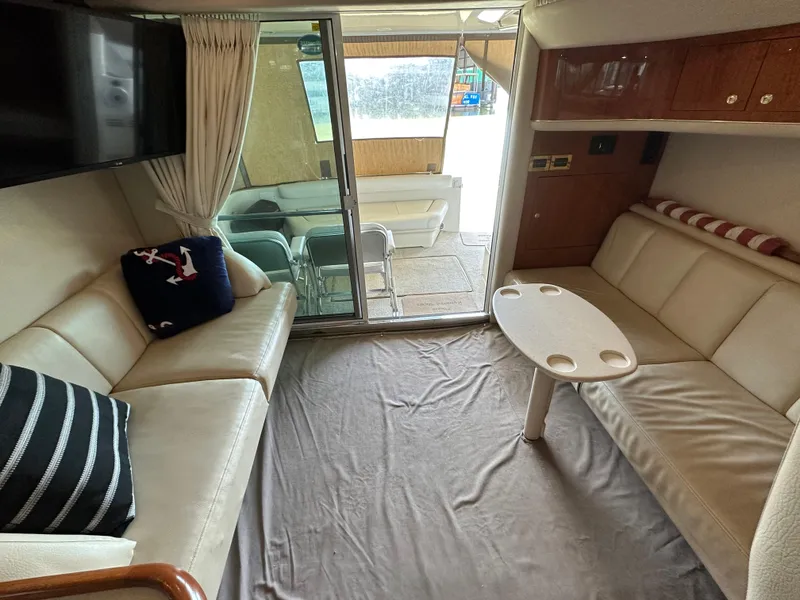 Slide: The Image of Interior of 1999 Sea Ray 400 Sedanbridge yacht with cozy seating and table. - 9