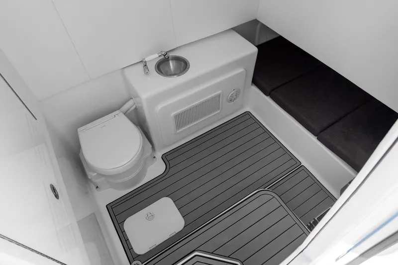 Slide: The Image of 2026 Front Runner 39 Center Console boat bathroom with toilet, sink, and cushioned seating. - 30
