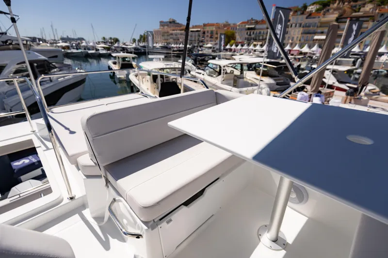 Slide: The Image of 2026 Beneteau Antares 11 Fly yacht with seating area in a marina setting. - 10