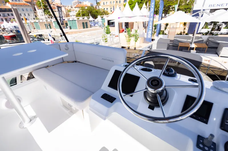 Slide: The Image of 2026 Beneteau Antares 11 Flybridge helm with seating, docked at marina. - 16
