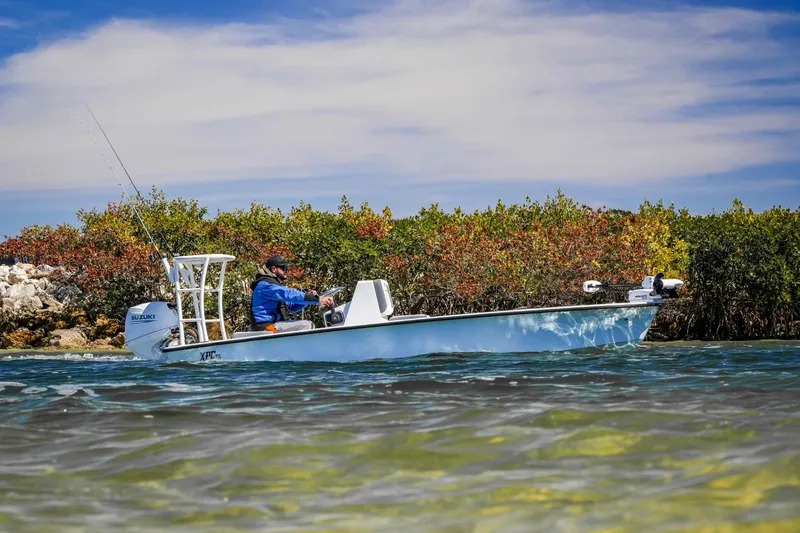 Slide: The Image of Custom XPC 16 boat navigating coastal waters, 2025 model, with lush greenery in the background. - 21
