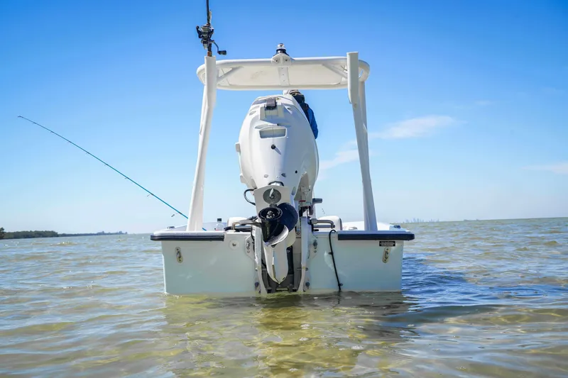 Slide: The Image of Custom XPC 16 boat, 2025 model, in shallow water with fishing rod, clear sky. - 23