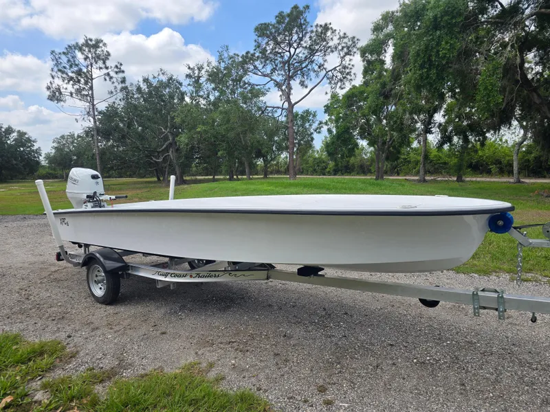 Slide: The Image of Custom XPC 16 boat on trailer, 2025 model, parked outdoors with trees in the background. - 3