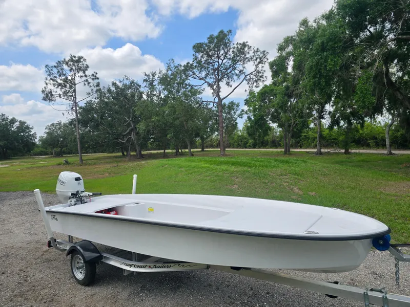 Slide: The Image of Custom XPC 16 boat on trailer, 2025 model, parked outdoors with trees in the background. - 4