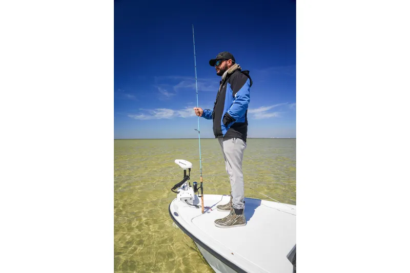 Slide: The Image of Man fishing on a Custom XPC 16 boat, 2025 model, in clear shallow waters. - 9