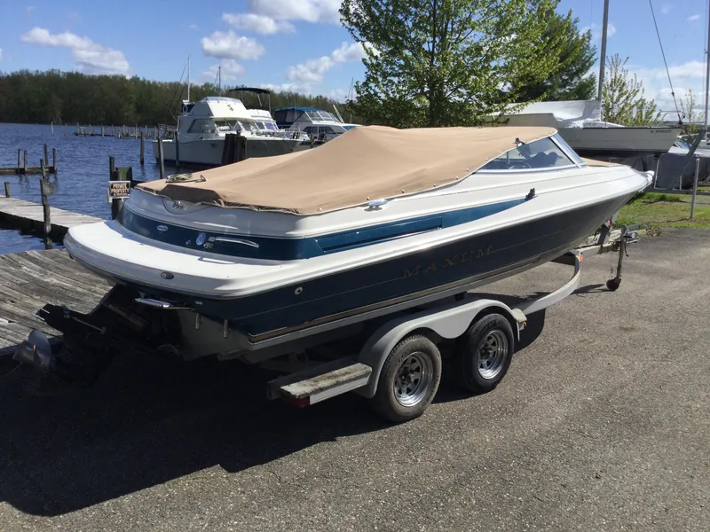 Slide: The Image of 1997 Maxum 2100 SR boat on trailer by lakeside dock. - 2