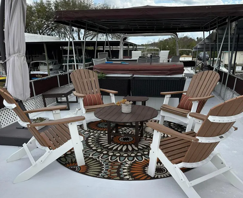 Slide: The Image of Stardust Cruisers 6816 houseboat deck with Adirondack chairs and patterned rug, year 2000 model. - 12