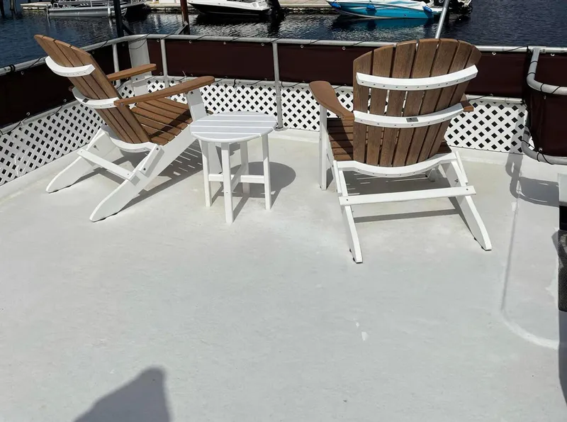 Slide: The Image of Two wooden chairs and a table on a Stardust Cruisers 6816 houseboat deck. - 14