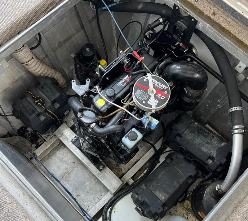 Slide: The Image of Engine compartment of a 2000 Stardust Cruisers 6816 houseboat, featuring a Mercury 3.0 motor. - 16
