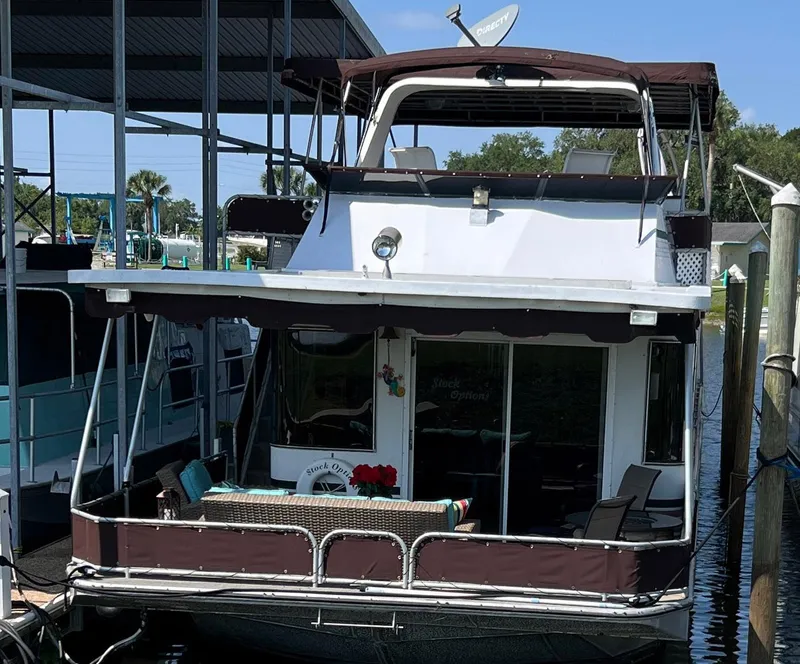 Slide: The Image of Houseboat docked in marina, Stardust Cruisers 6816, year 2000, with outdoor seating area. - 17