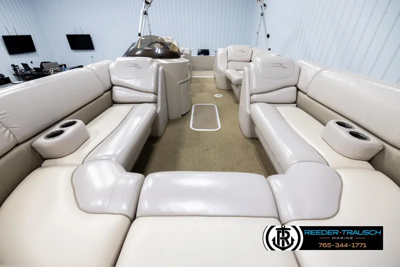 Slide: The Image of 2013 Bennington 2375 GCW pontoon boat interior with beige seating and cup holders. - 13