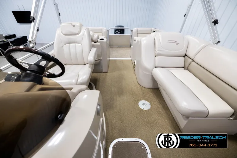Slide: The Image of 2013 Bennington 2375 GCW pontoon boat interior with beige seating and steering wheel. - 14