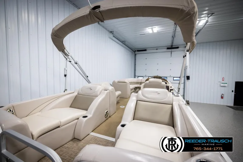 Slide: The Image of 2013 Bennington 2375 GCW pontoon boat with beige seating in a showroom. - 24
