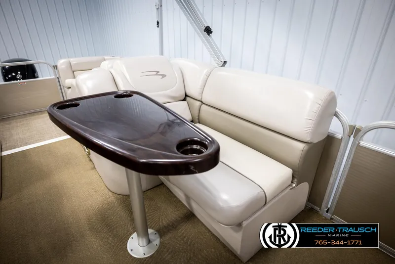 Slide: The Image of 2013 Bennington 2375 GCW boat interior with beige seating and dark wood table. - 27