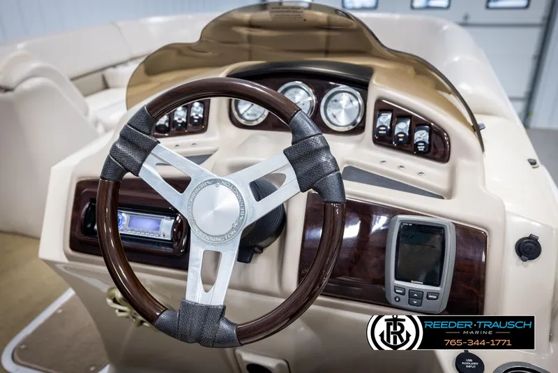 Slide: The Image of Steering wheel and dashboard of 2013 Bennington 2375 GCW boat, featuring gauges and controls. - 29