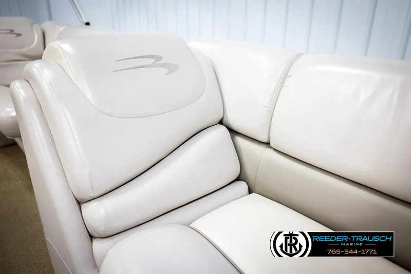 Slide: The Image of 2013 Bennington 2375 GCW boat interior with white leather seating, Reeder-Trausch Marine logo visible. - 42