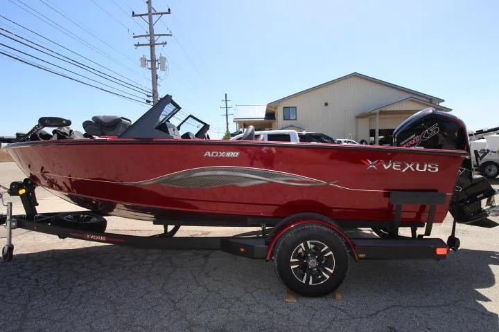 The Image of 2025 Vexus ADX180LS boat in red, parked on a trailer outdoors. - 0