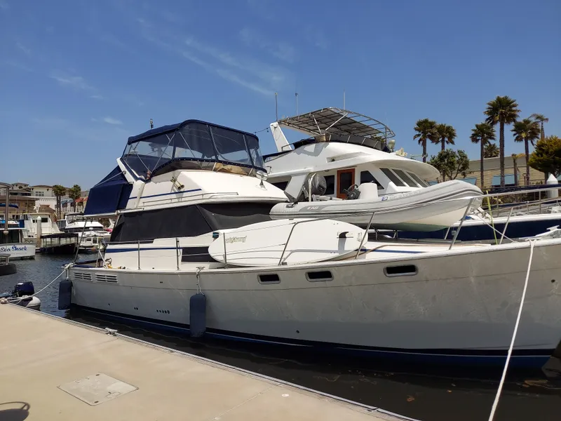 Slide: The Image of 1987 Bayliner 3870 Motoryacht docked at marina under clear blue sky. - 1