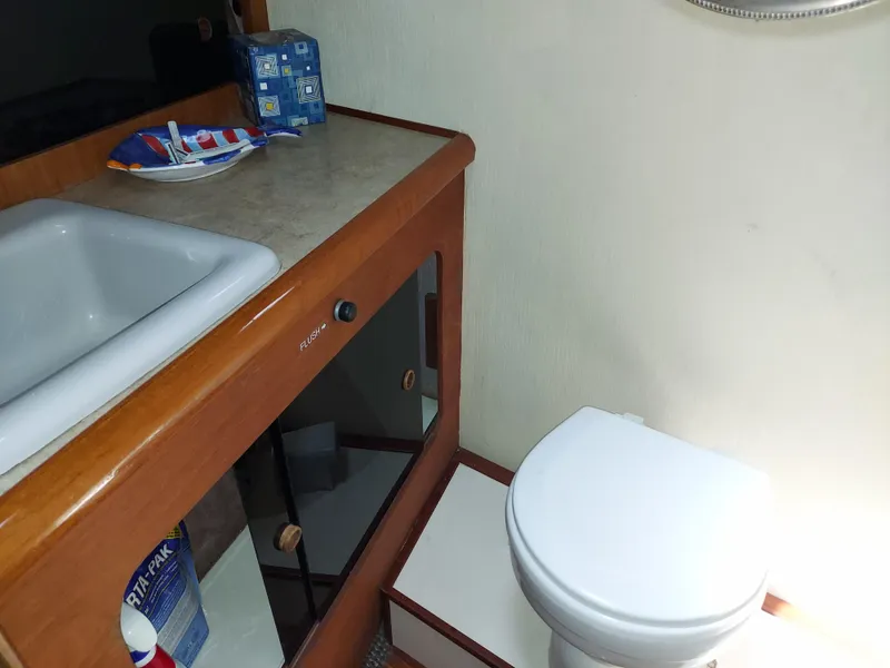 Slide: The Image of 1987 Bayliner 3870 Motoryacht bathroom with sink, toilet, and storage cabinet. - 14